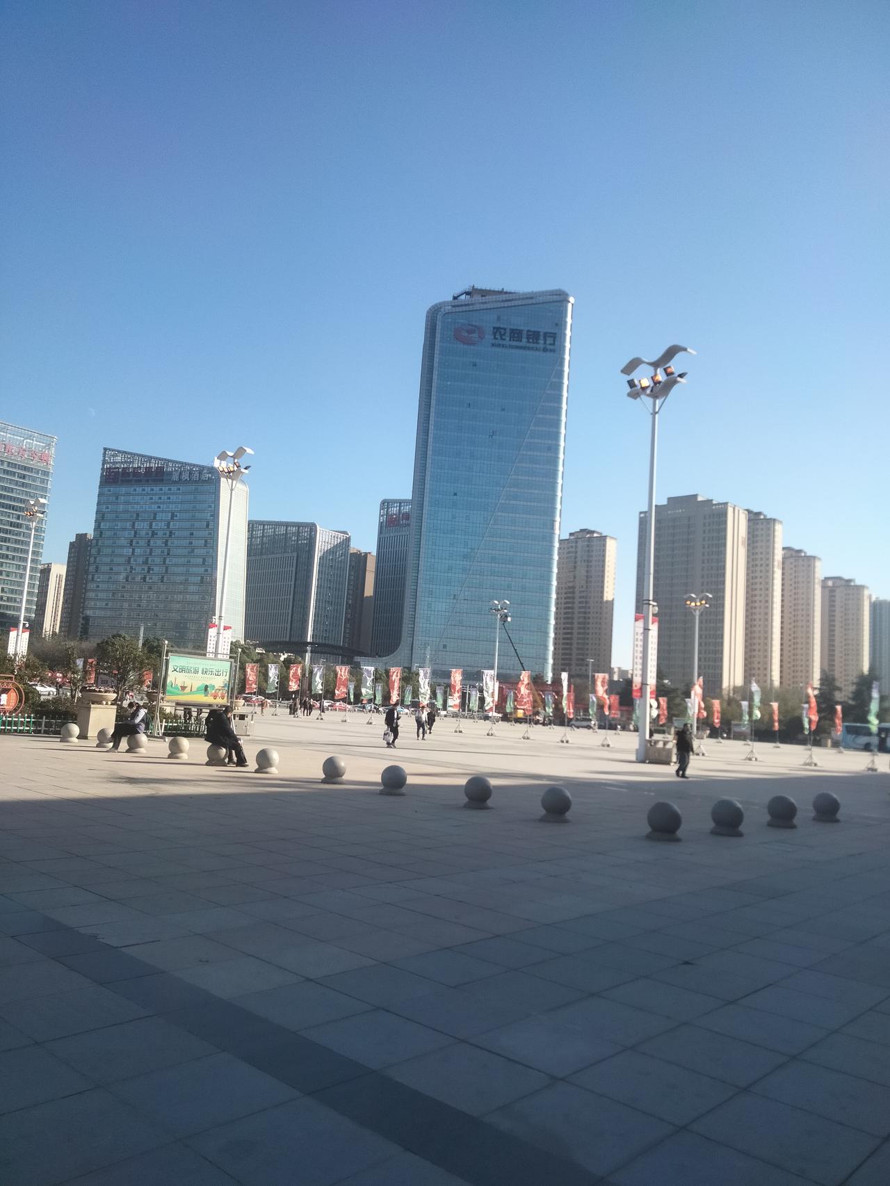 驻马店西站的发展与繁荣，高铁站附近高楼林立。