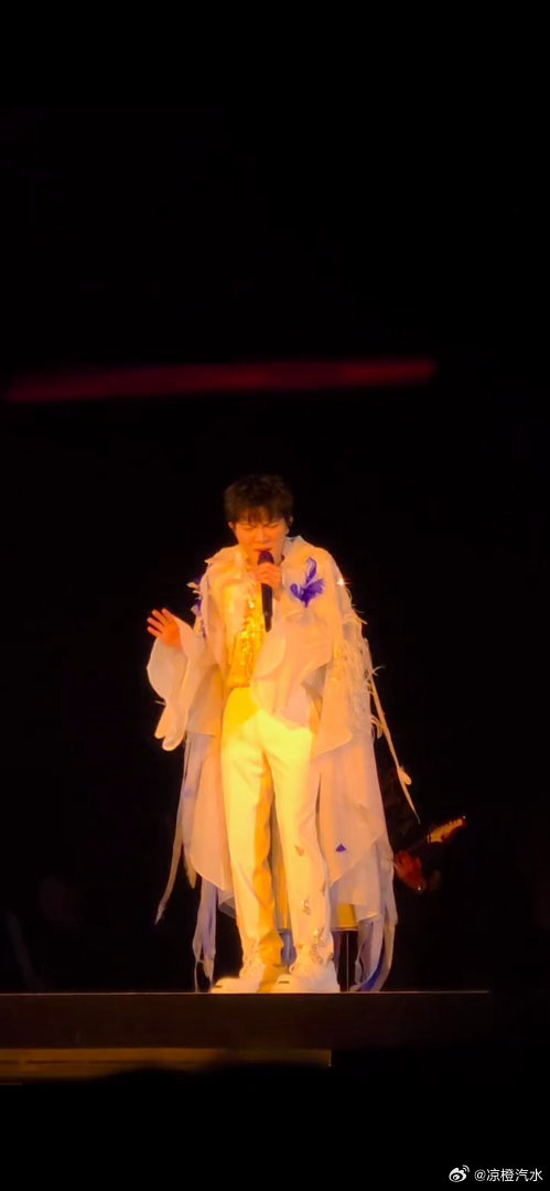 周深 暖黄色的追光像一层温柔的滤镜，把他整个人包裹在光晕里，搭配这套自带仙气的白