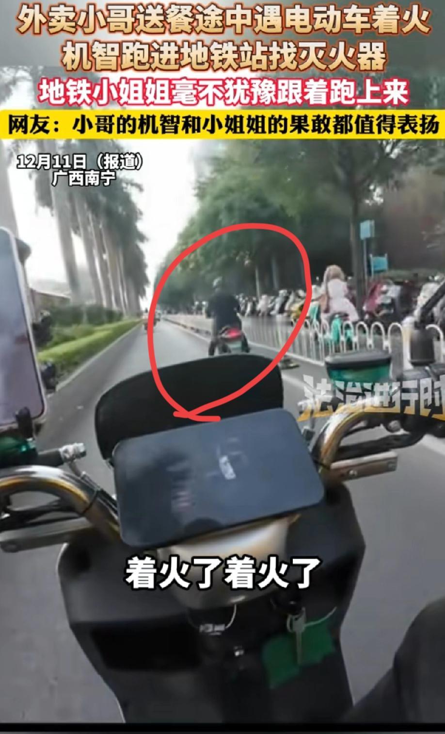 广西南宁，一名外卖小哥瞧见前方行驶的电动车正冒着烟，赶忙大声呼喊：“着火了，着火