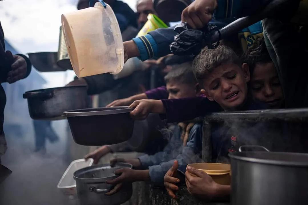 美联社照片：

在加沙地带以南的拉法，饥饿的巴勒斯坦人排队领取免费餐食。

国际