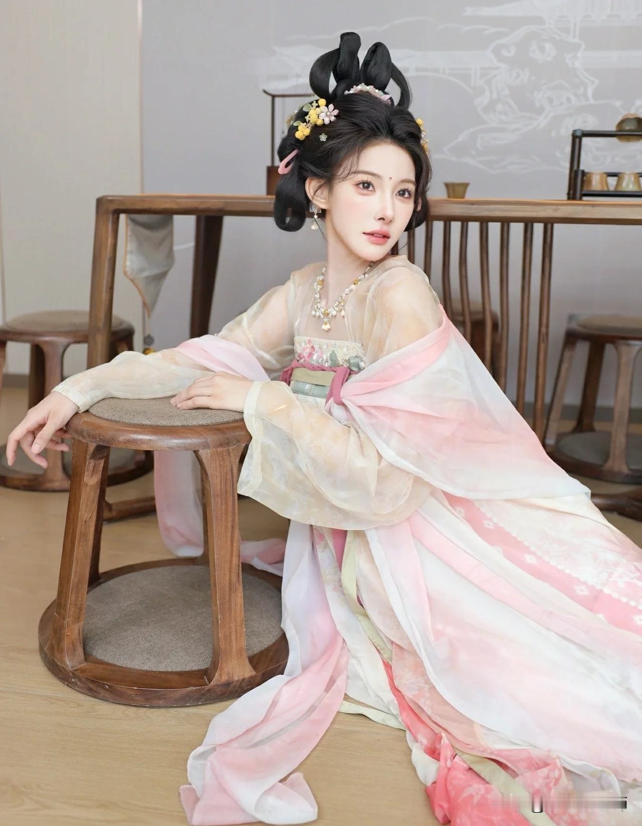 古风美人坐于木凳，粉裙飘逸，古典韵味十足。