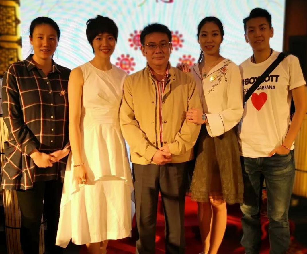 4位女排姑娘与教练员同框：一袭白裙的魏秋月短发利落无瑕，笑容明艳动人；中间的蔡斌