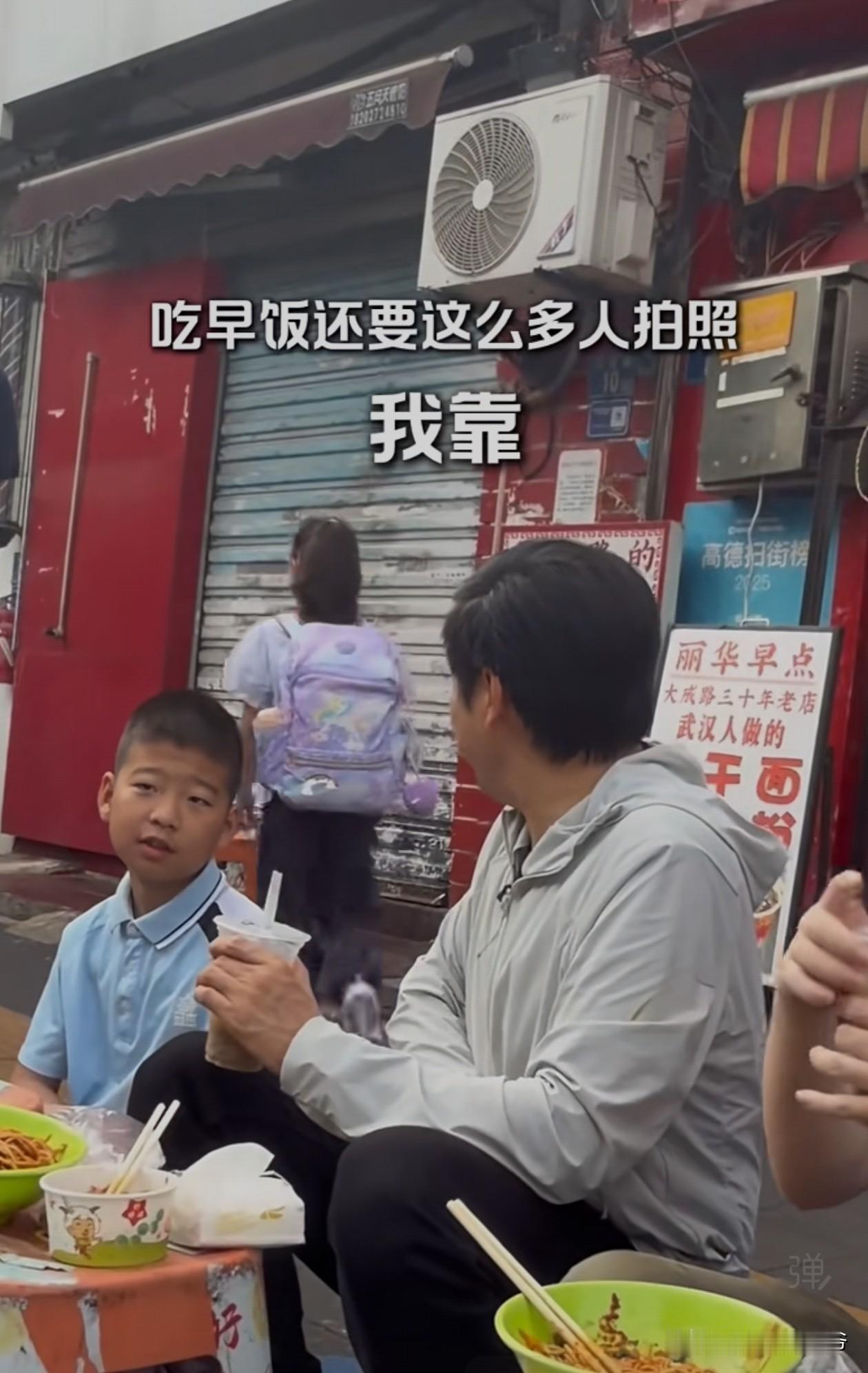 雷总学黄总，坐在路边吃貌似同款碗面，被路过小孩姐感慨：吃早饭这么多人拍照，（此处