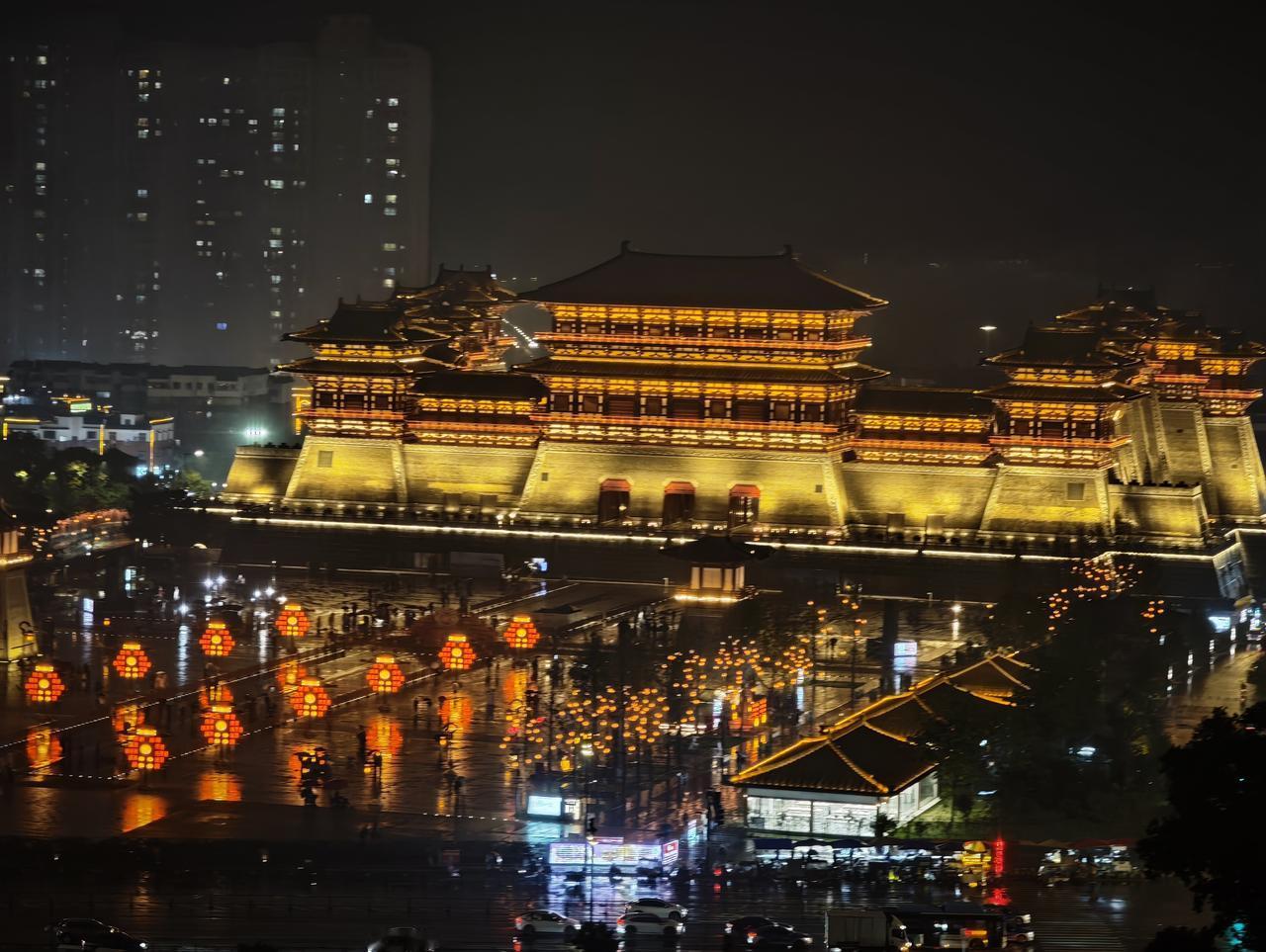 灯光秀 夜幕低垂，雨后的广场宛如一面巨大的明镜，将璀璨的灯火尽数揉碎在倒影里。巍
