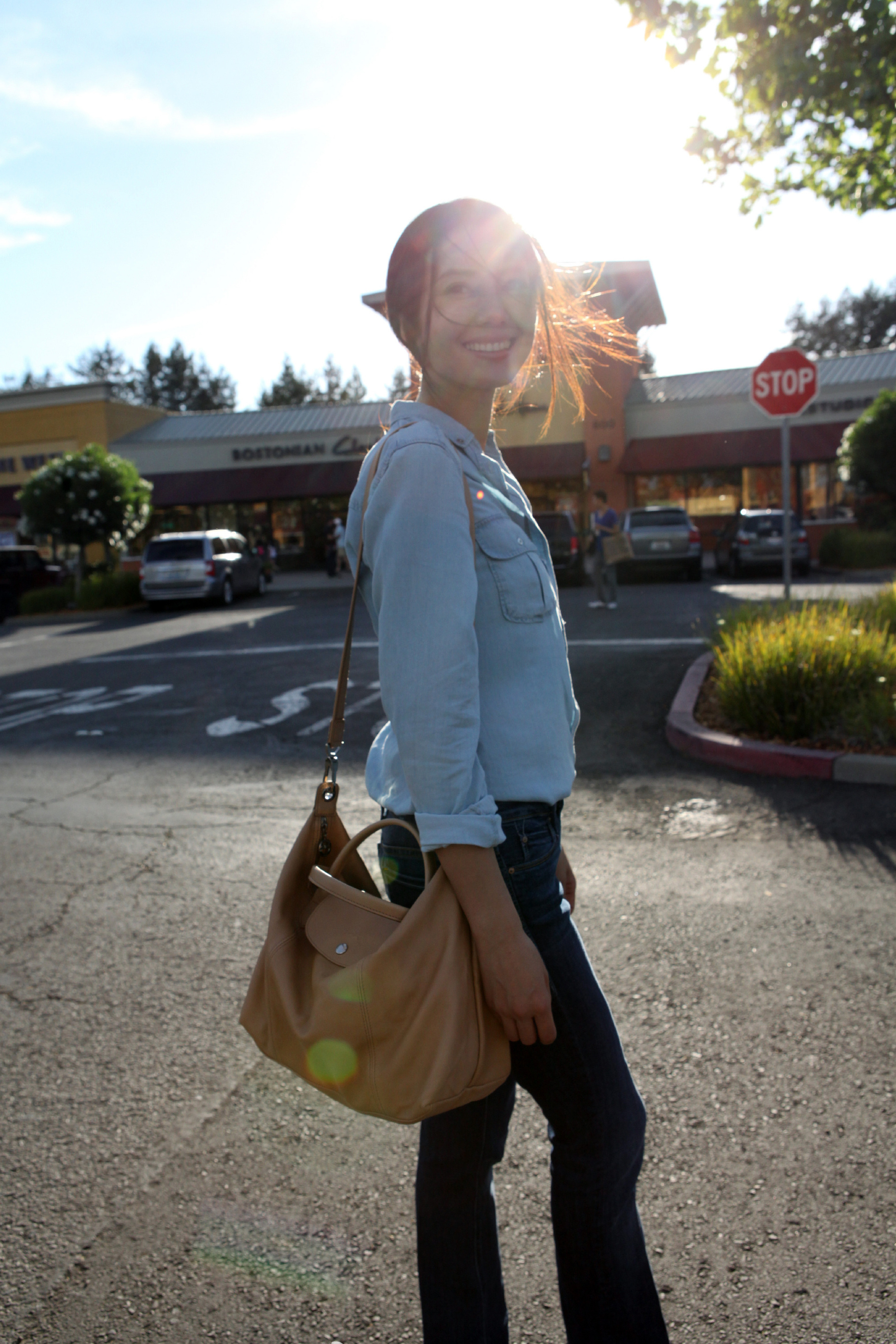 一种随性又治愈的日常感。午后的阳光从身后洒下，形成温柔的光晕，发丝在光里轻扬，笑