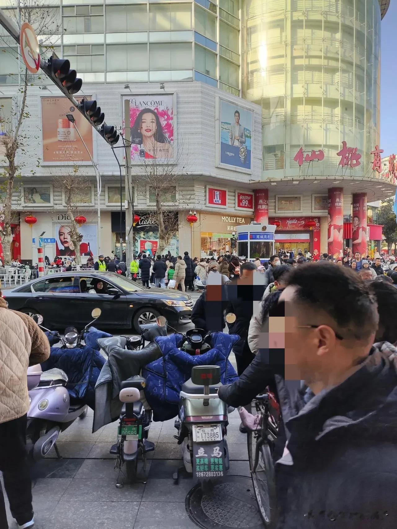 这是仙桃市除夕的前一天，街上真的可以用车水马龙，人流如织来形容。
也不对，车，流