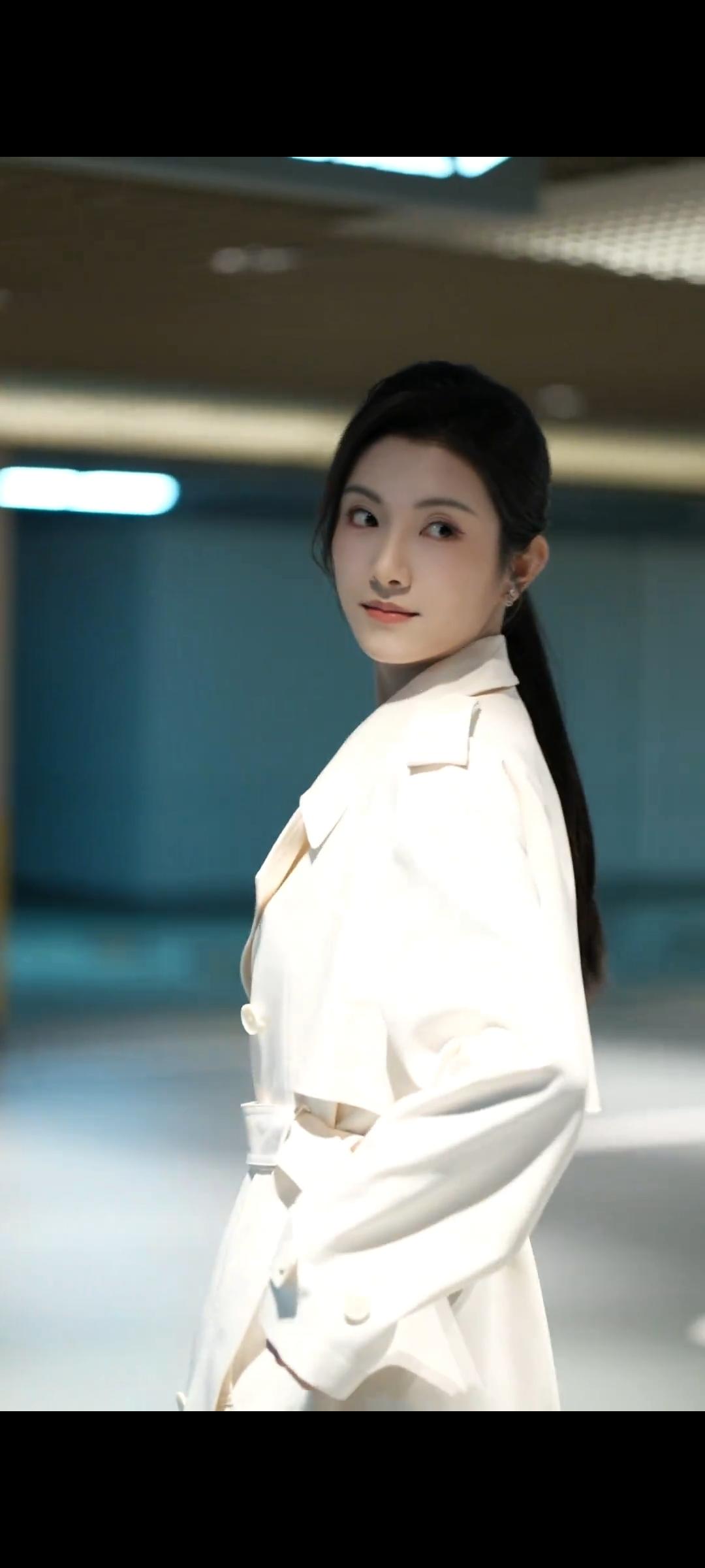 晚风与米白风衣的邂逅。

米白风衣是初冬的质感密码，利落剪裁衬托美女身形挺拔，车