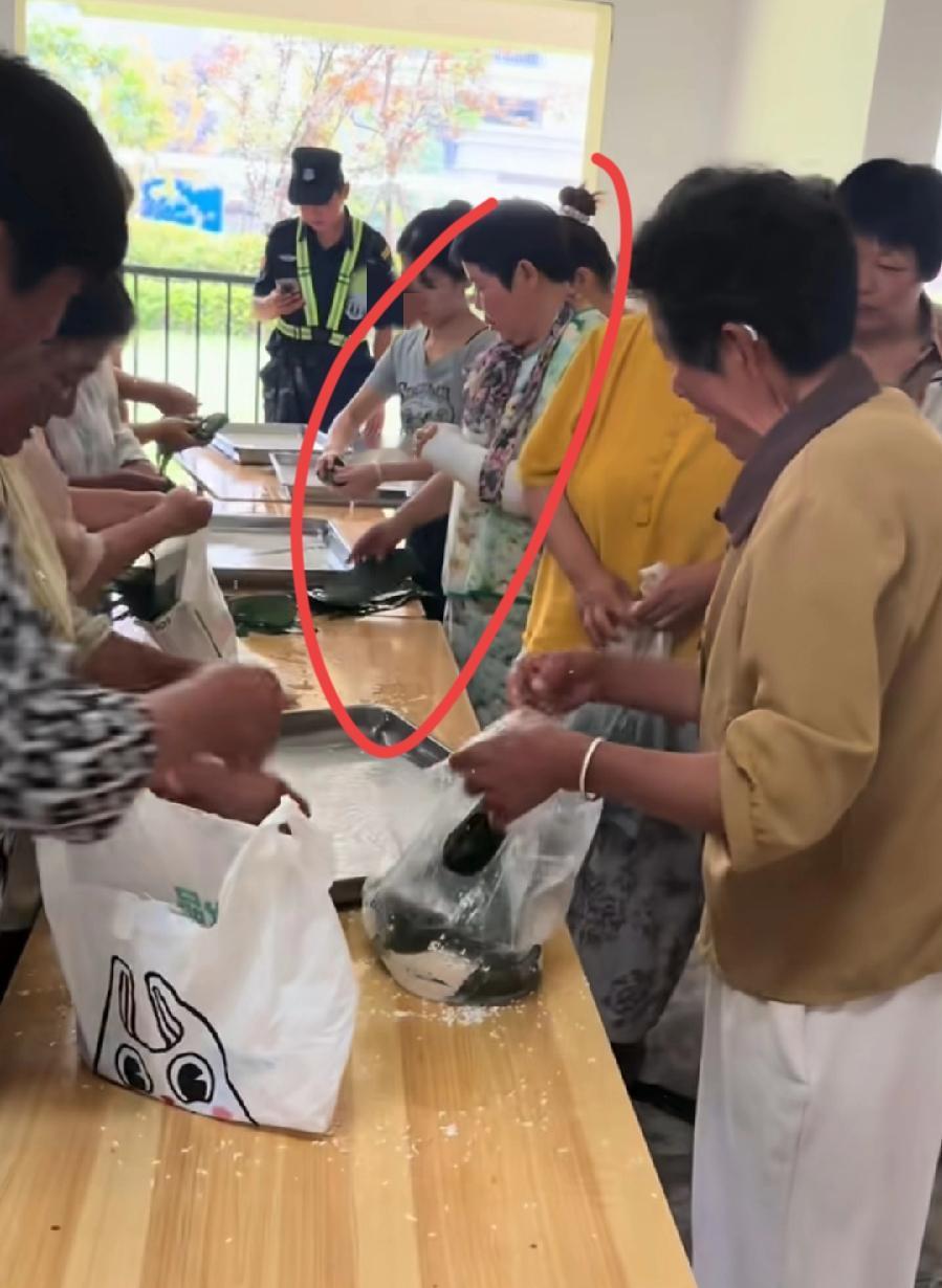 安徽一物业包粽子活动，大妈胳膊受伤了，包扎着绑带，还去包粽子呢！左手不能动了，右
