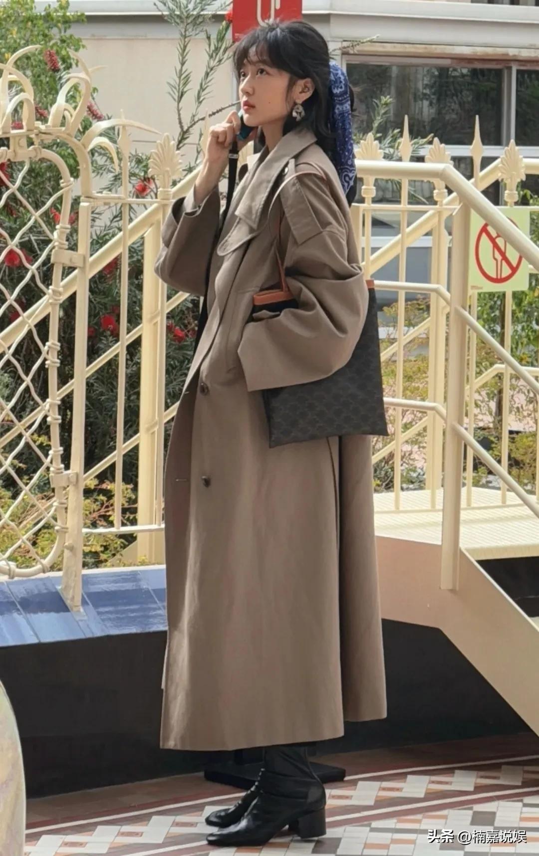 孙千现身西班牙巴塞罗那购物。
穿着一件驼色的长风衣，脚踩靴子，头发用一块蓝色头巾