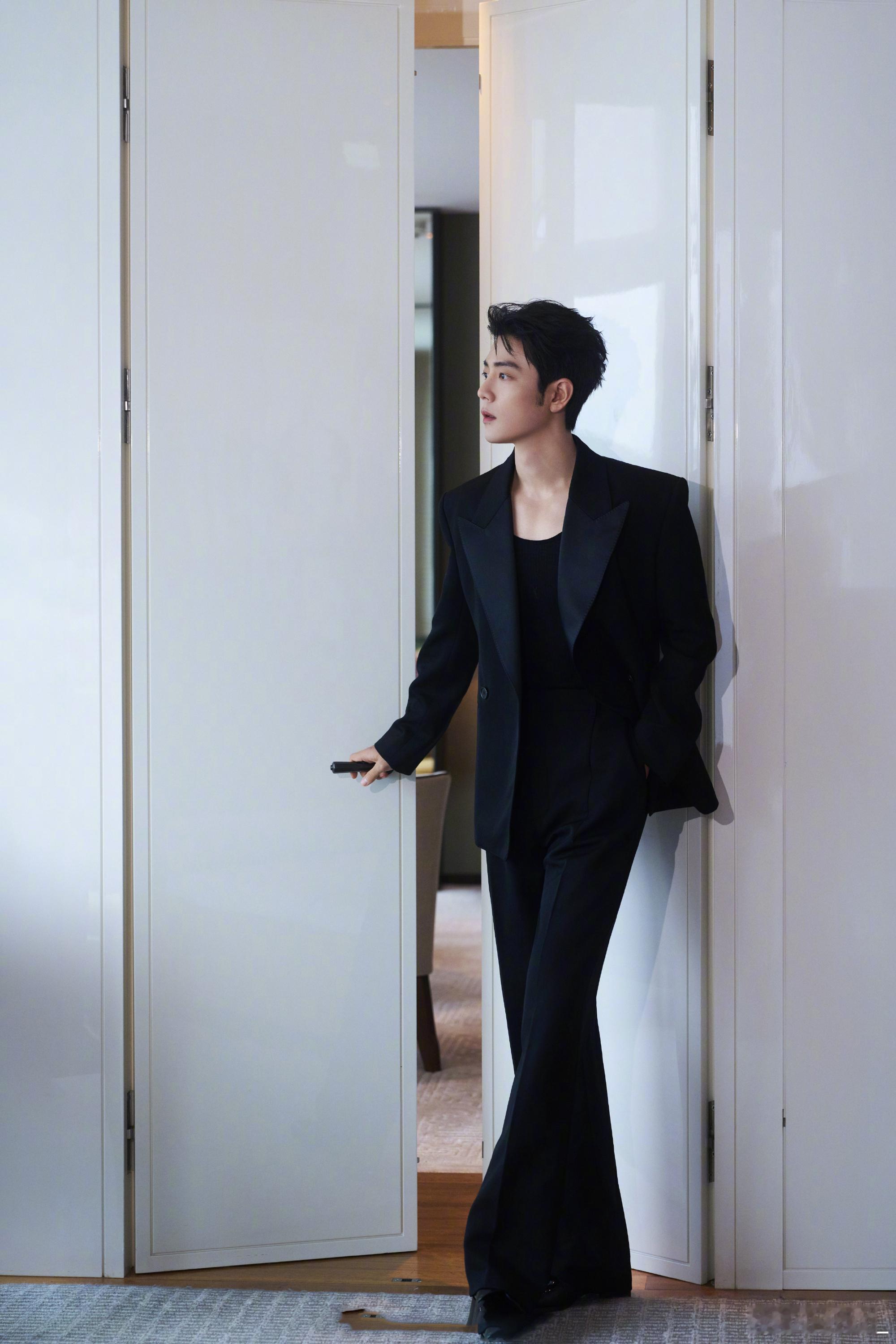 肖战身着SAINT LAURENT 黑色枪驳领修身西装，搭配薄底两面皮鞋，于香港