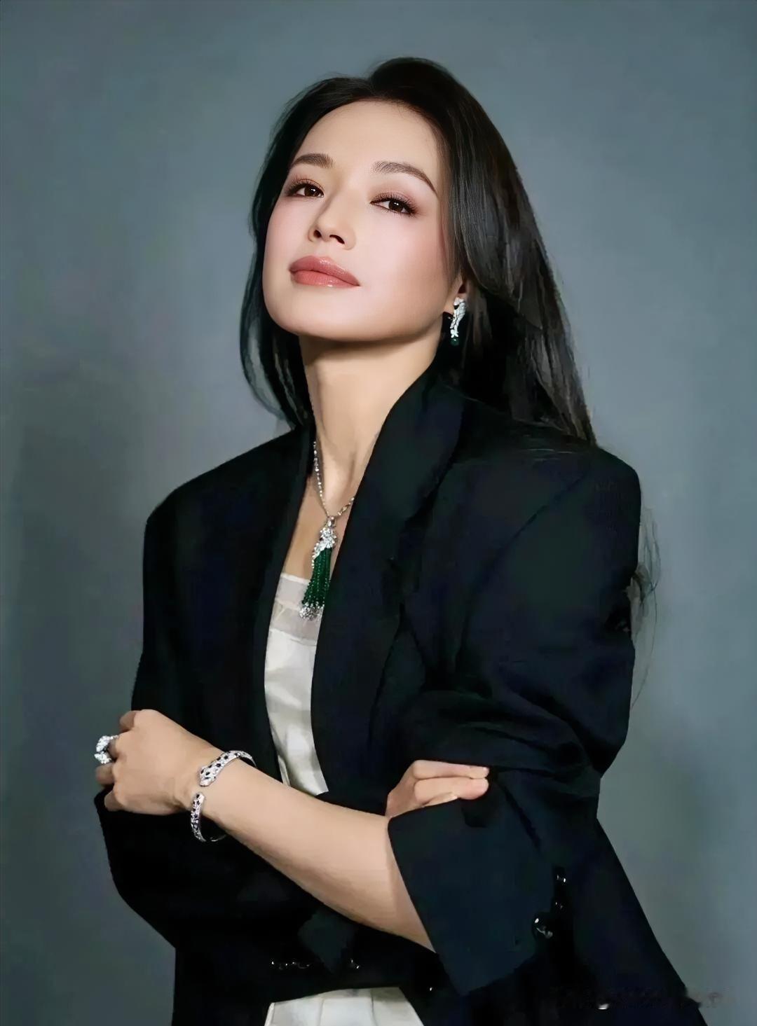 黑色西装利落剪裁，内搭纯白，绿宝石点缀，冷艳气场中透着高级优雅的摩登质感。