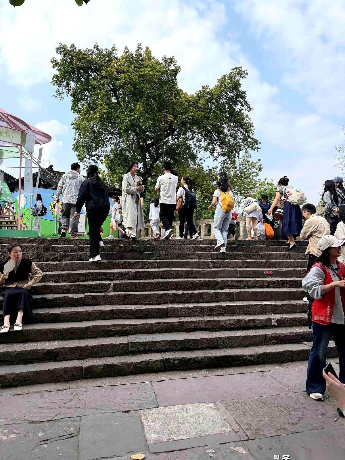 “我在重庆”四个大字前面，人头攒动，一个姑娘手机举到最高，脖子拧得像麻花，才勉强