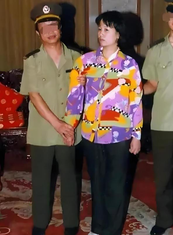2000年，刘艺霞被判死刑，照片中的她，身穿花衬衫，被两名警察押送着，面无表情，
