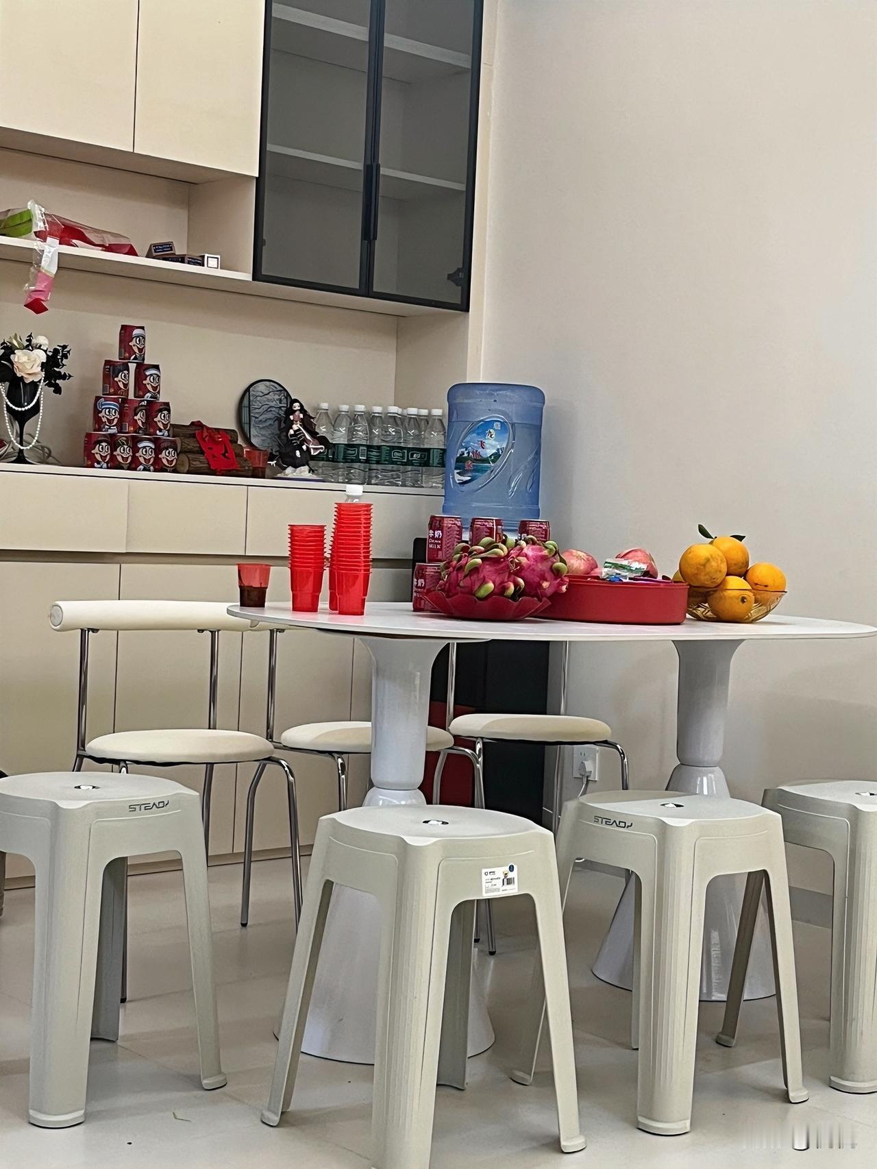 这小茶水间也太舒服了吧！

刚进门就瞅见桌上摆得满满当当——火龙果、橘子堆得冒尖