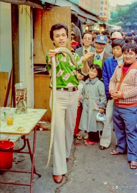 七十年代，台湾街头，一个卖药酒的人，像围观群众展示一条长蛇。原来，那边和我们大陆
