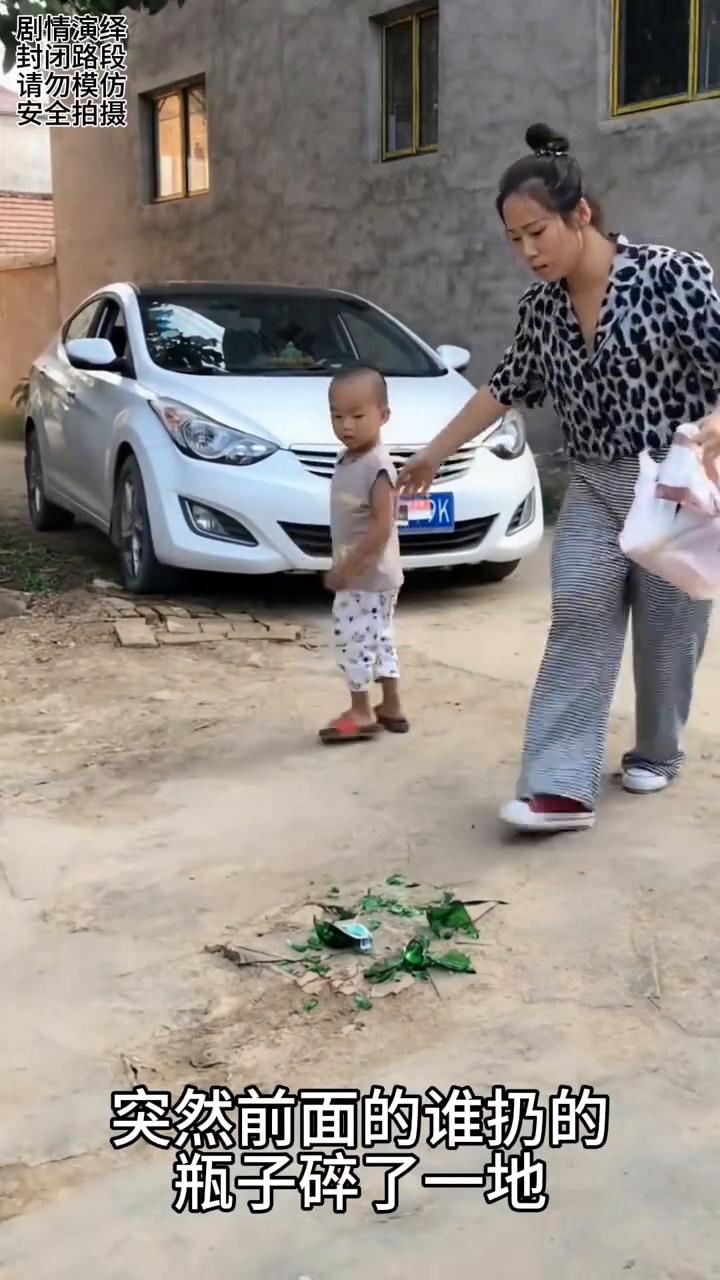 母子看到地上的一堆玻璃渣，下一秒他们去捡。
妈妈带着儿子在路上走着，突然前面的谁