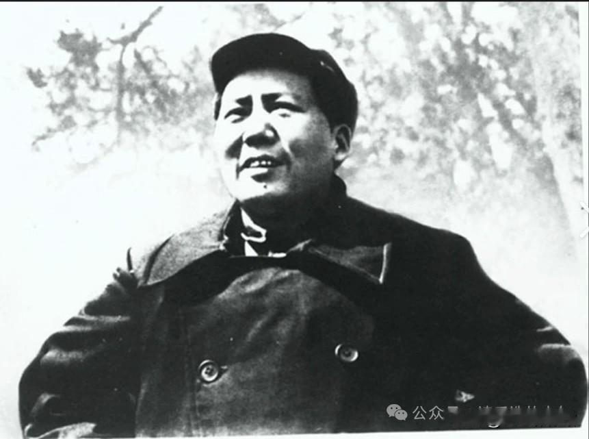 这是延安时期的经典黑白照片，毛泽东头戴八角军帽、身着双排扣呢军大衣，神情从容坚毅