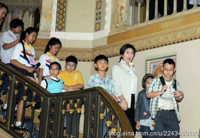 英拉牵着儿子的手和一群小朋友在一起，她儿子一定向朋友夸奖过自己的妈妈。毕竟英拉如