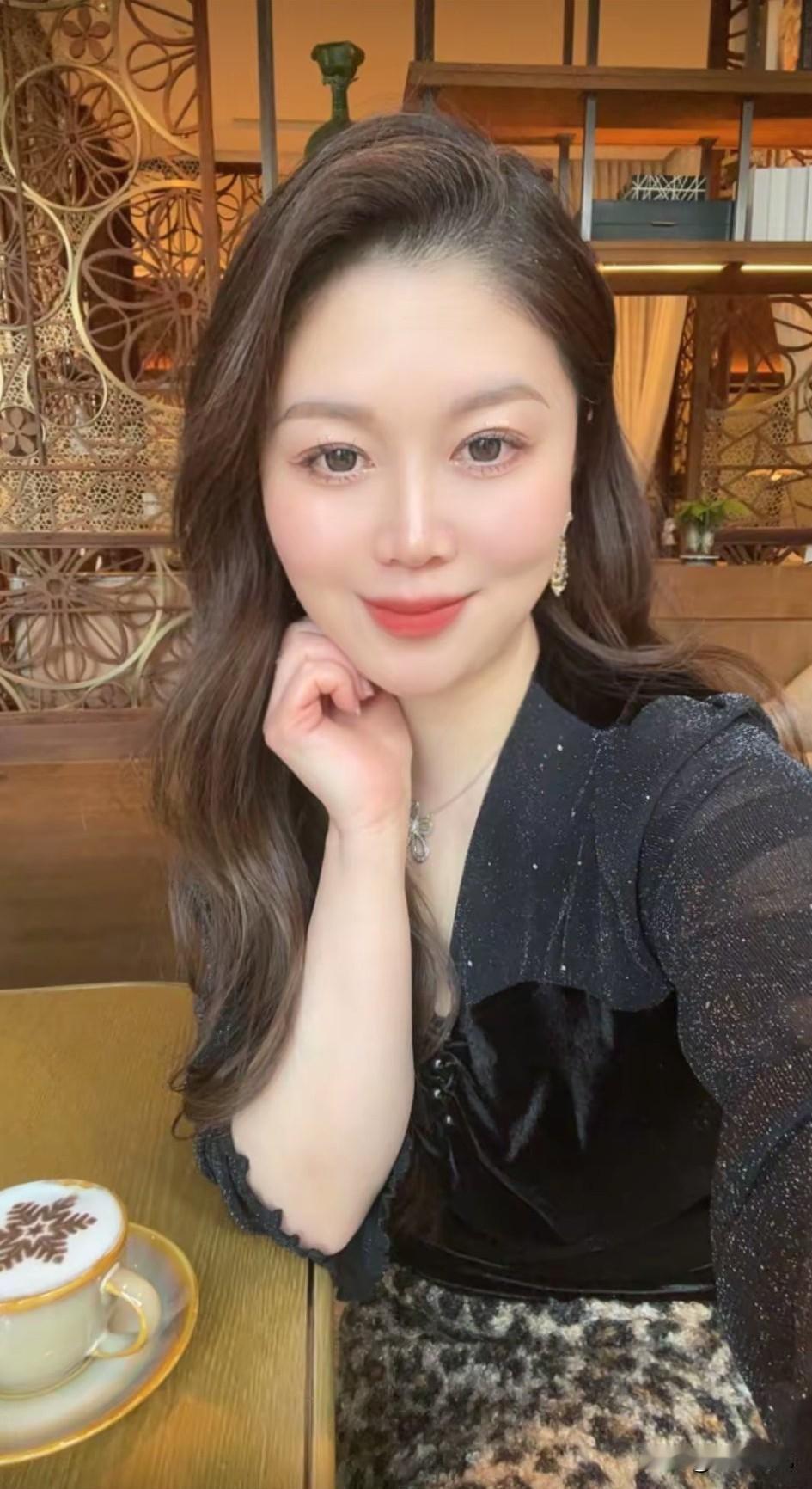 暖黄灯光像揉碎的金箔洒在木质桌面上，镂空雕花隔断晕着朦胧的光，身后书架上的绿植悄