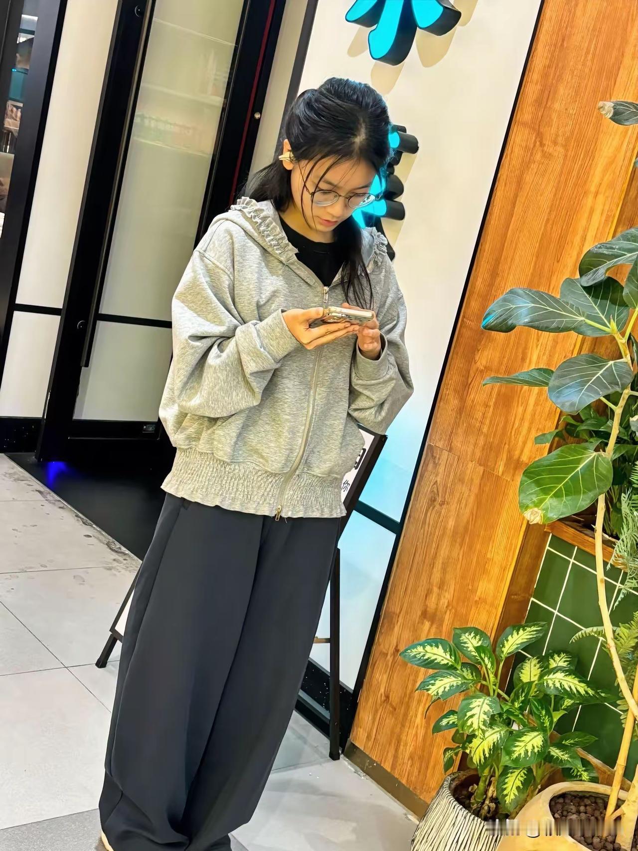 宽松灰帽衫配垂感阔腿裤，是今日份的慵懒松弛穿搭。低头刷手机的瞬间，把都市里的慢节