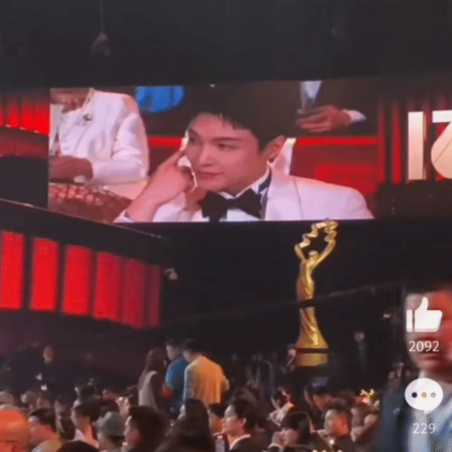 所有人都在正襟危坐，只有你莲在旁若无人的傻乐，突然在大屏幕上看到自己，十分娇羞的