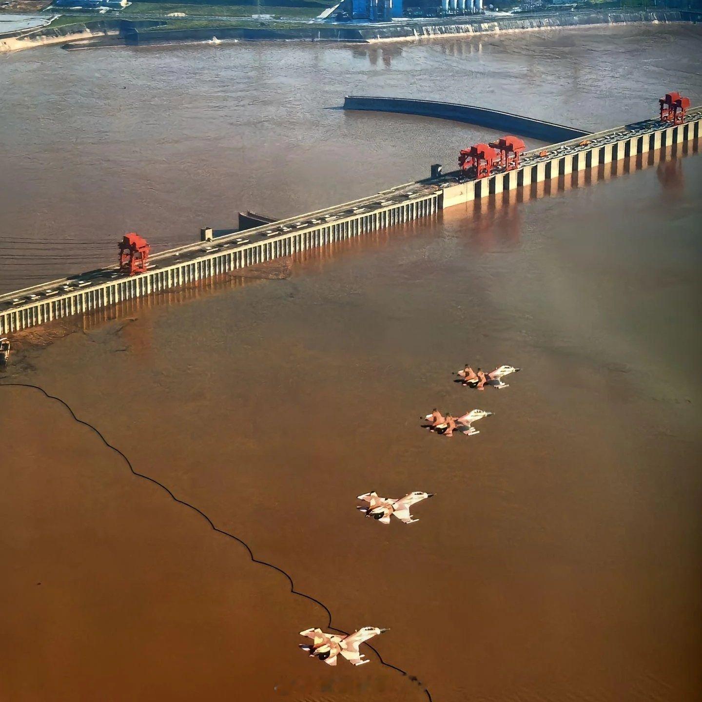 4 架苏 - 30MKK双座多用途重型战斗机，呈编队超低空沿水面飞越坝区，机身荒