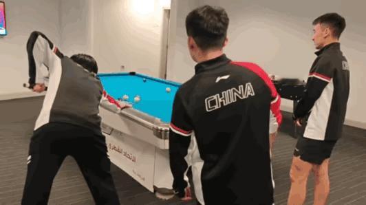 结束了训练，大家都在等待班车发车，
旁边有台球桌，
王楚钦抓紧跑过去，着急忙活的