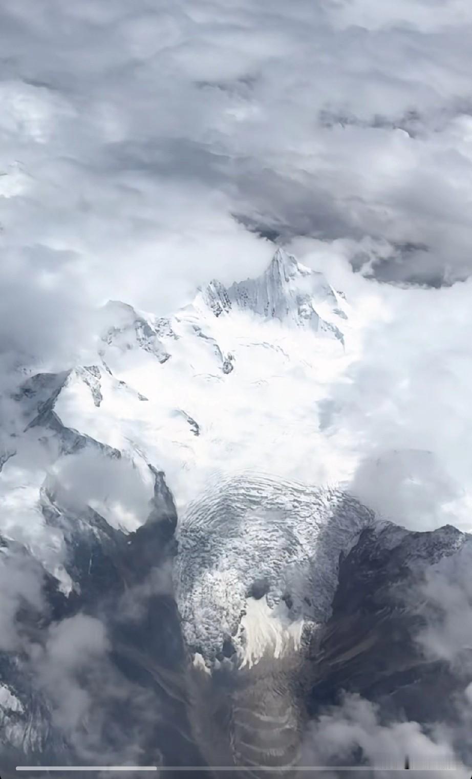 这座雪山的冰川很有意思，表面就像水波纹一样，仿佛是一条被冻住的冰河。你知道这座雪