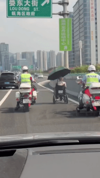 老人驾驶电动轮椅在公路上行驶。
身边还有两名交警贴身守护。
这样的交警真是太暖心