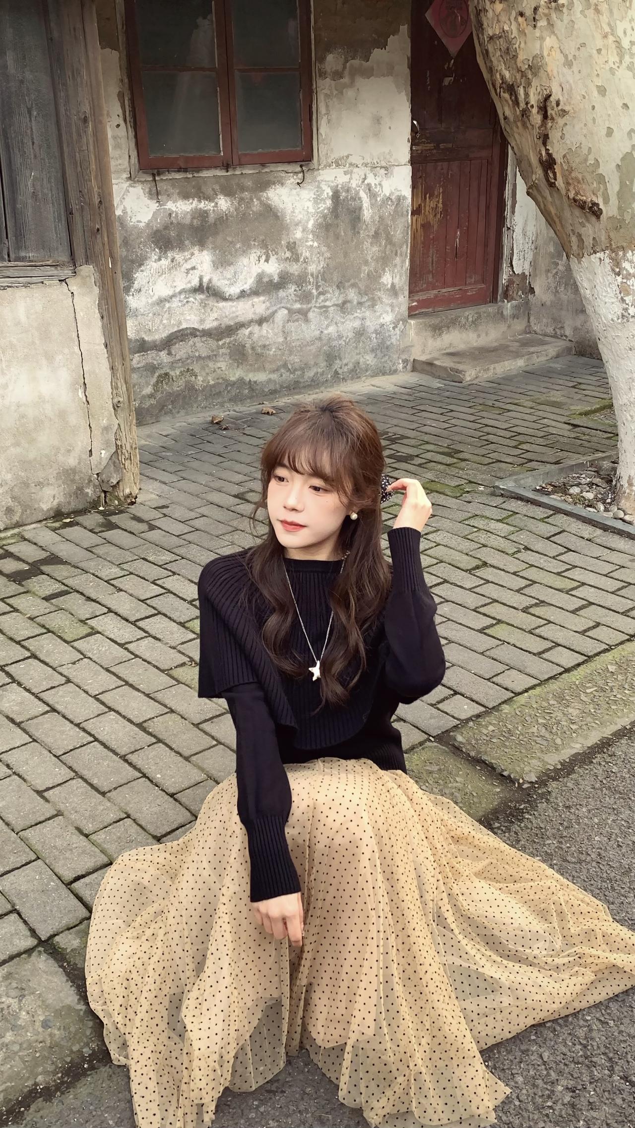 低饱和配色+轻盈纱裙，和花海、老巷都适配度满分
黑色短款披肩针织衫➕杏色波点网纱