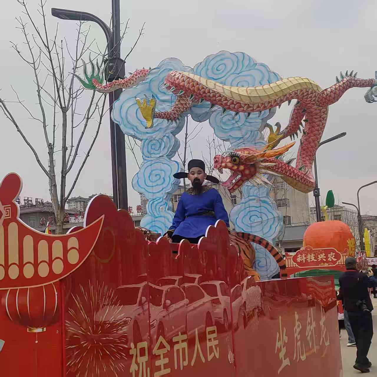 天南地北大拜年彩车之上，祥龙昂首腾云起，古韵装扮添意趣。“坐虎针龙”的民俗底蕴，