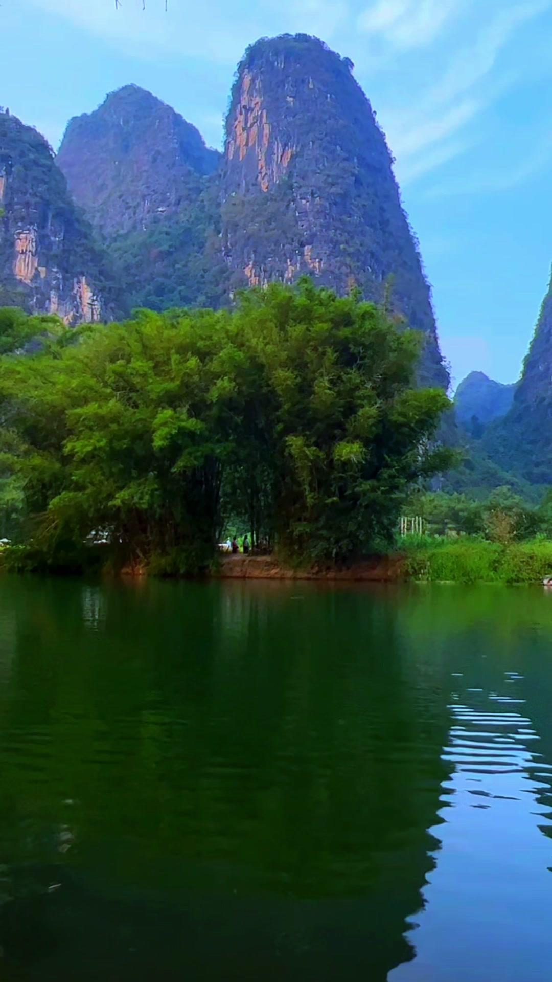 乘着竹筏漂在碧色的水面上，两岸喀斯特小山错落立在雾气里，风裹着湿润的草木香吹过来
