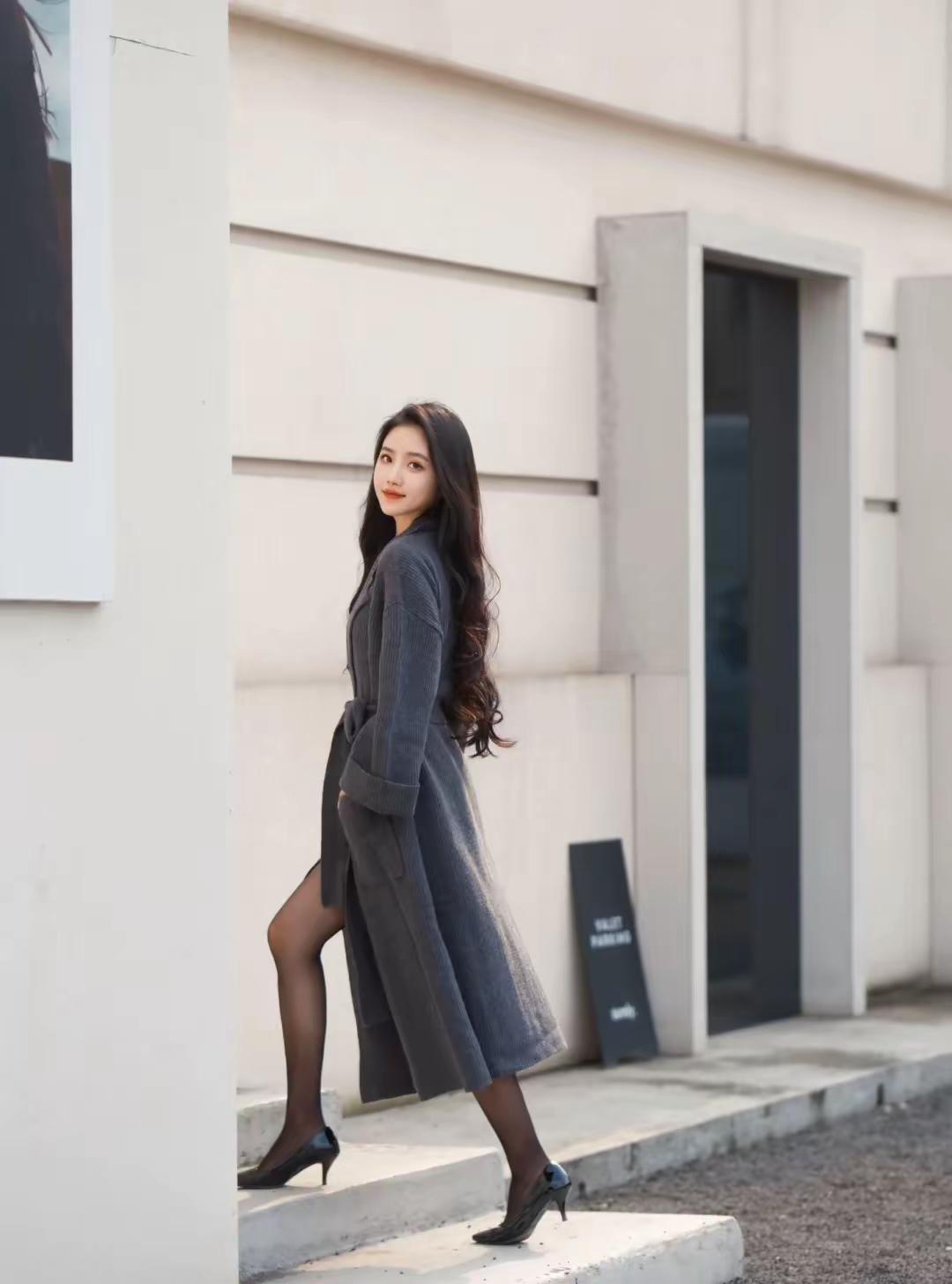 灰调针织风衣裹住松弛的氛围感，焦糖色内搭和黑丝高跟又添几分精致。
踩着阳光走过街