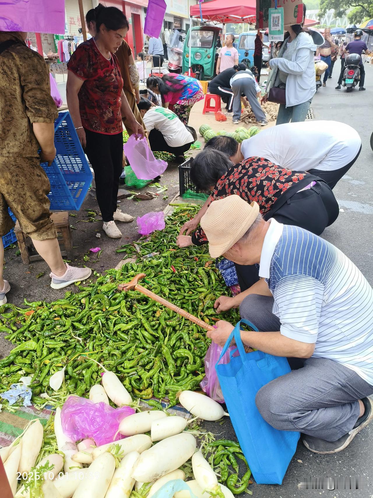 地摊上，一元钱一斤的辣椒吸引了众多人竞相抢购。说实话，普通辣椒至少要五元一斤。