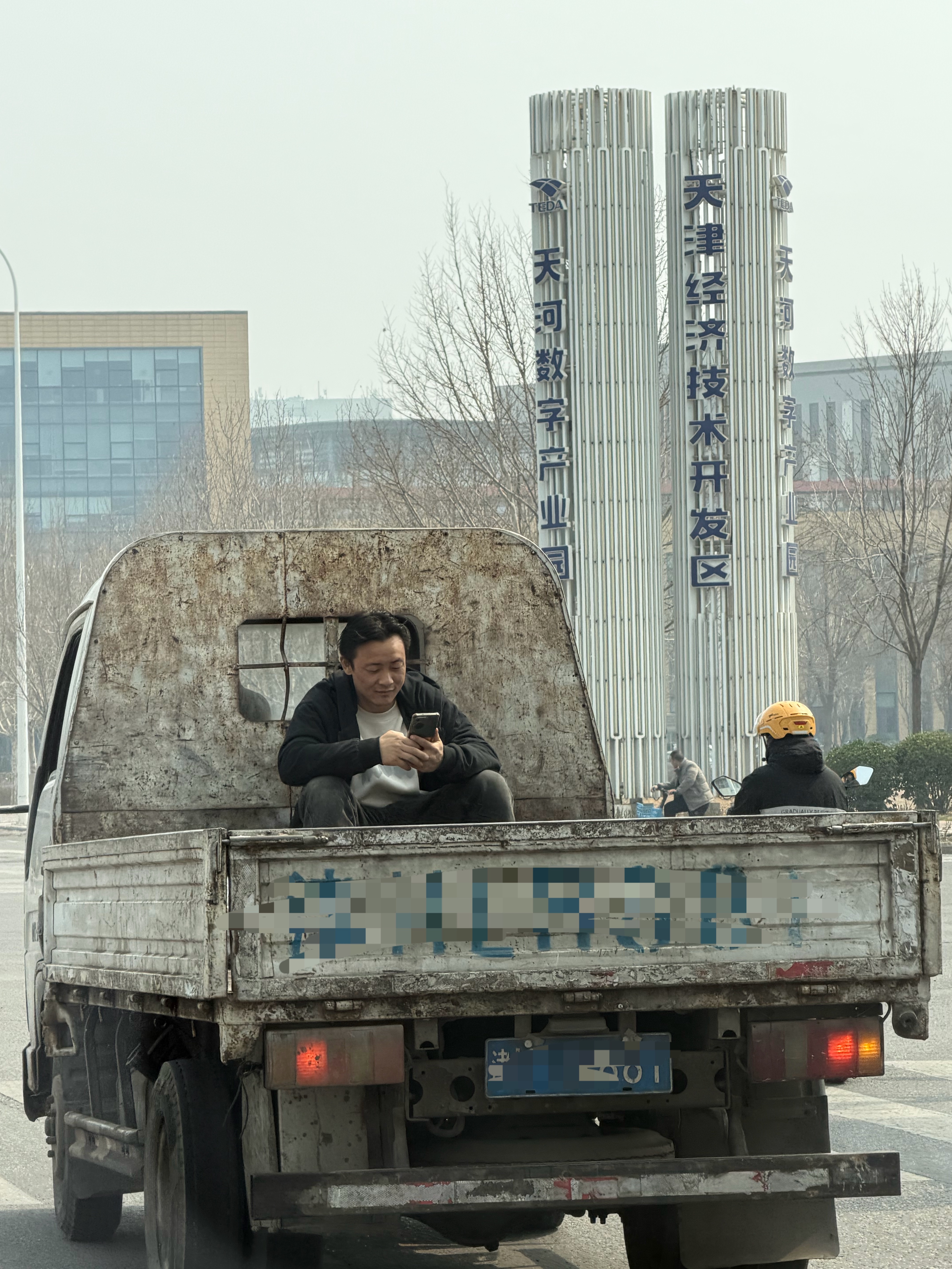 大哥在货车后斗上，边刷手机变笑你坐过货车后斗吗？我坐过，哈哈哈 天津