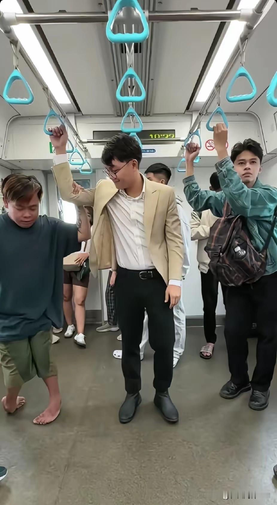 地铁上，残疾小伙子有些费劲地拉着吊环，站在旁边的陌生男子看了看后，突然伸出了一只