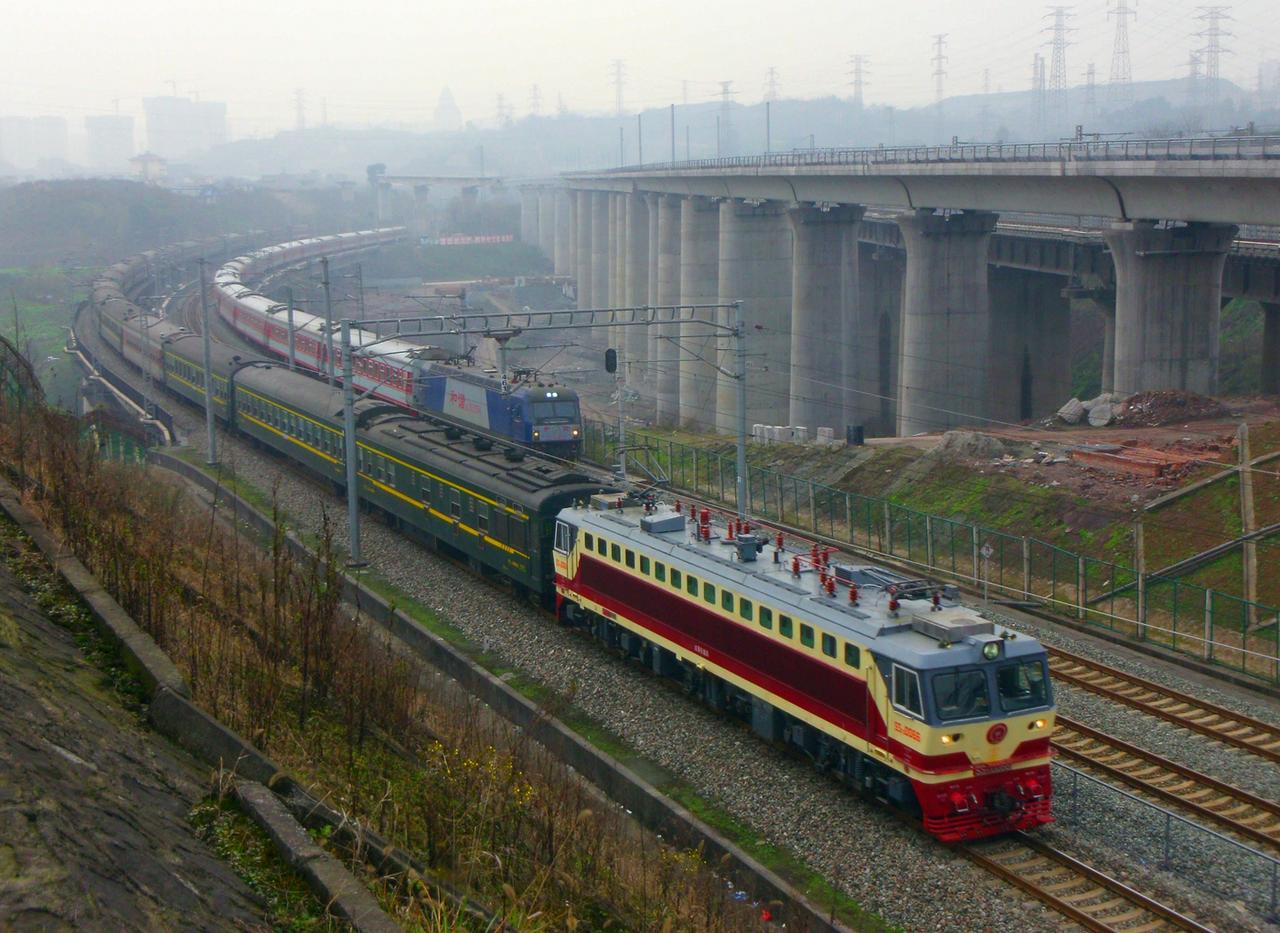 十年前在金渝大道跨线桥附近拍摄两趟不同线路上的普速客车同时经过此处，近处的列车是