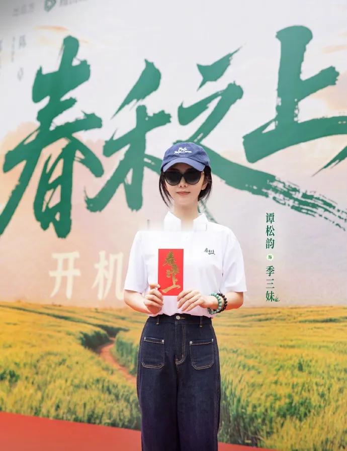 谭松韵亮相新剧开机仪式，白T搭深蓝牛仔裤，拉高腰线优化身形。蓝帽配黑墨镜，灵动又