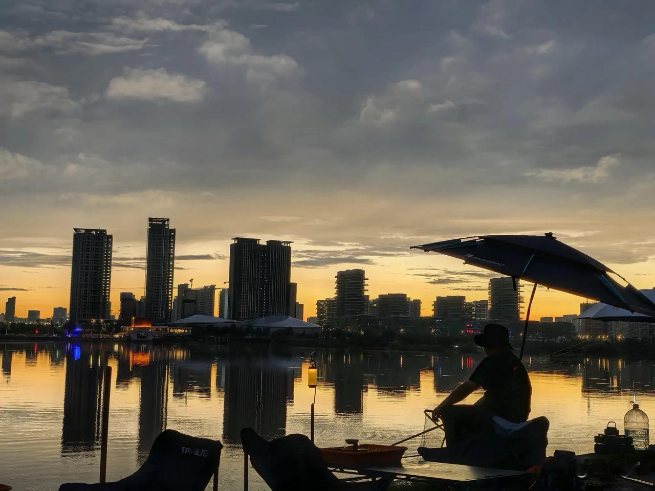当落日把半边河面熬成金色，伞下的小马灯亮了起来，钓椅一瘫，把鱼钩抛进河里，我连鱼