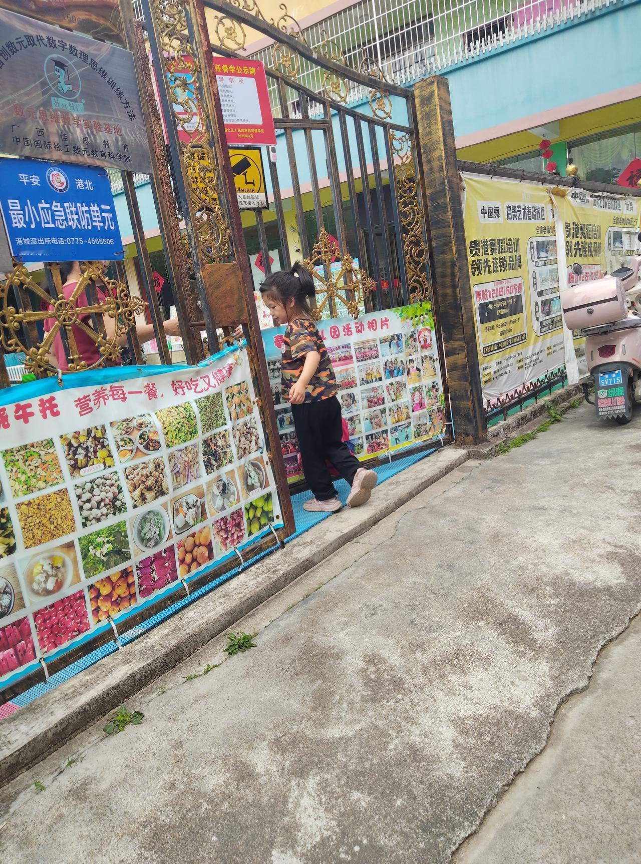 看着这张照片，忽然觉得幼儿园的时光真好。门口贴满的餐食和活动照片，藏着老师的用心