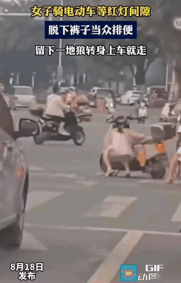 一个穿吊带裙子的年轻女子，在十字路口等红绿灯时，随地小便！她不是傻就是坏。要不，