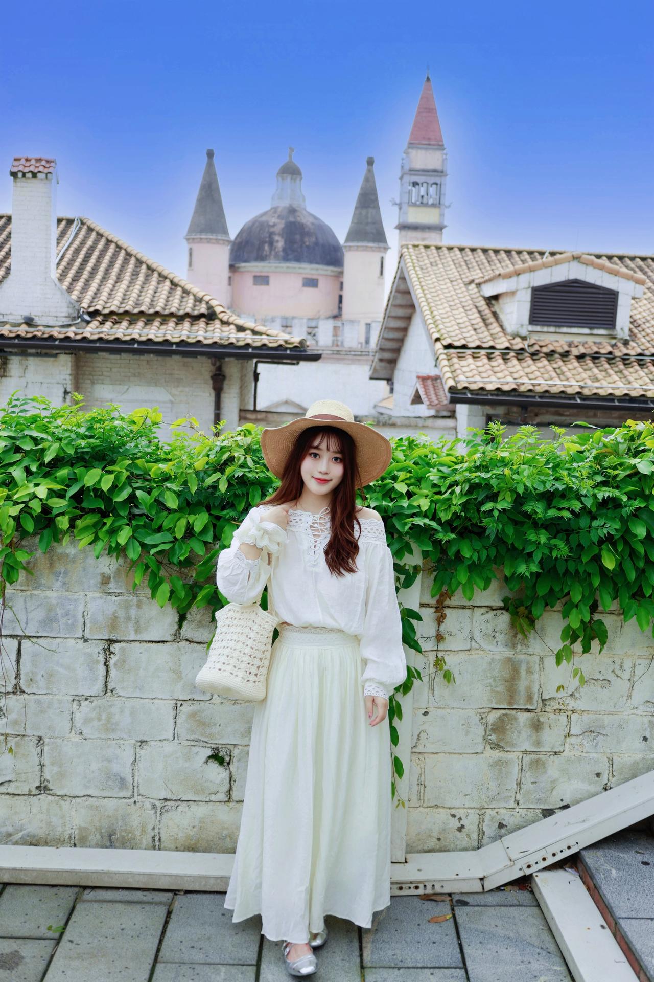 蓝天、尖顶城堡与满眼绿意，一身干净的白衣长裙，配上草帽与草编包。

在温柔的异域