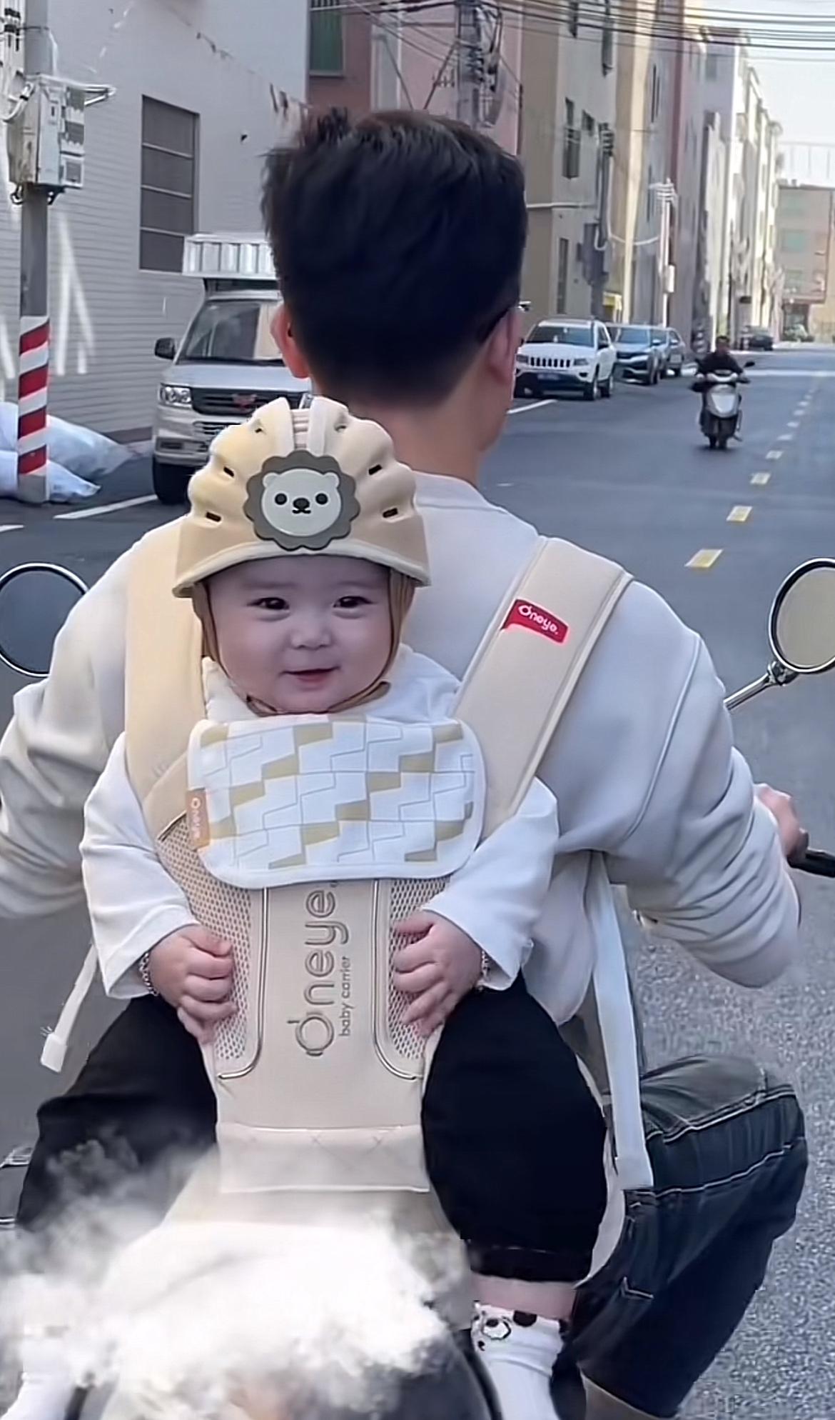 零零后爸爸带娃方式真是别具一格，开着电动车背着萌娃，这画面太有爱了。想象那萌娃肉