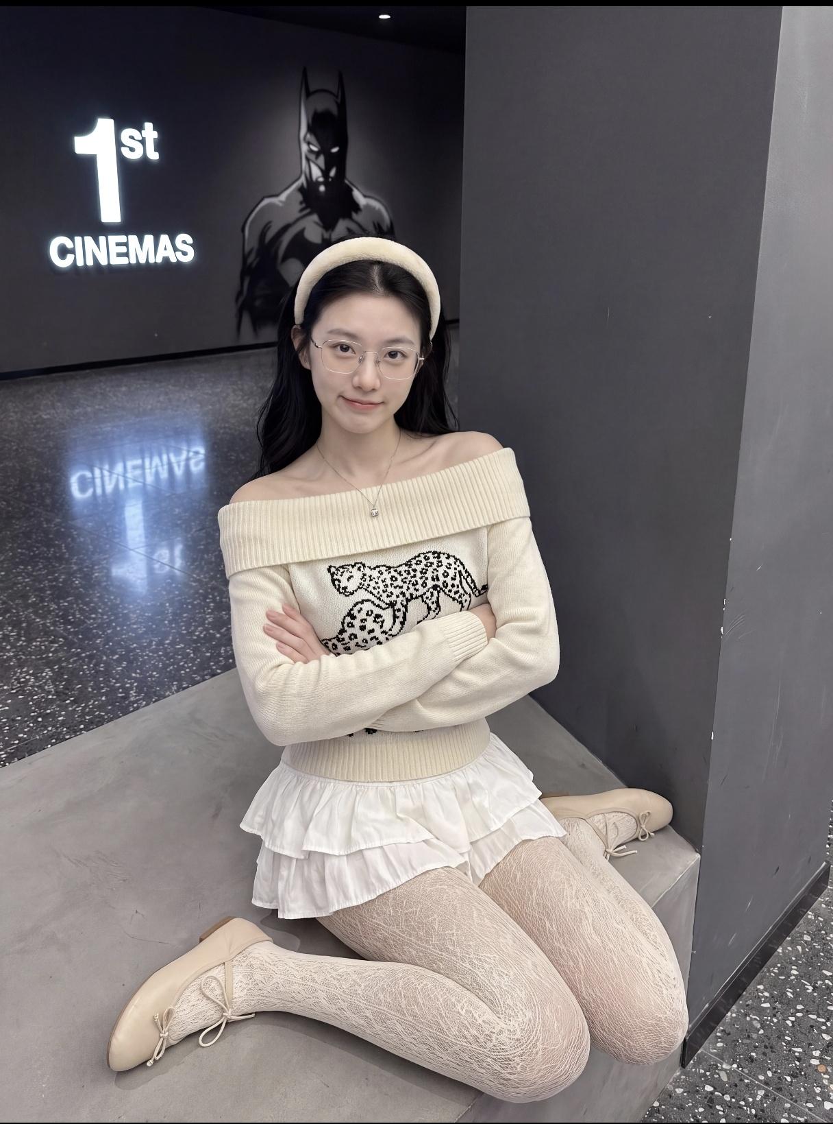 一个女孩在电影院前拍照。