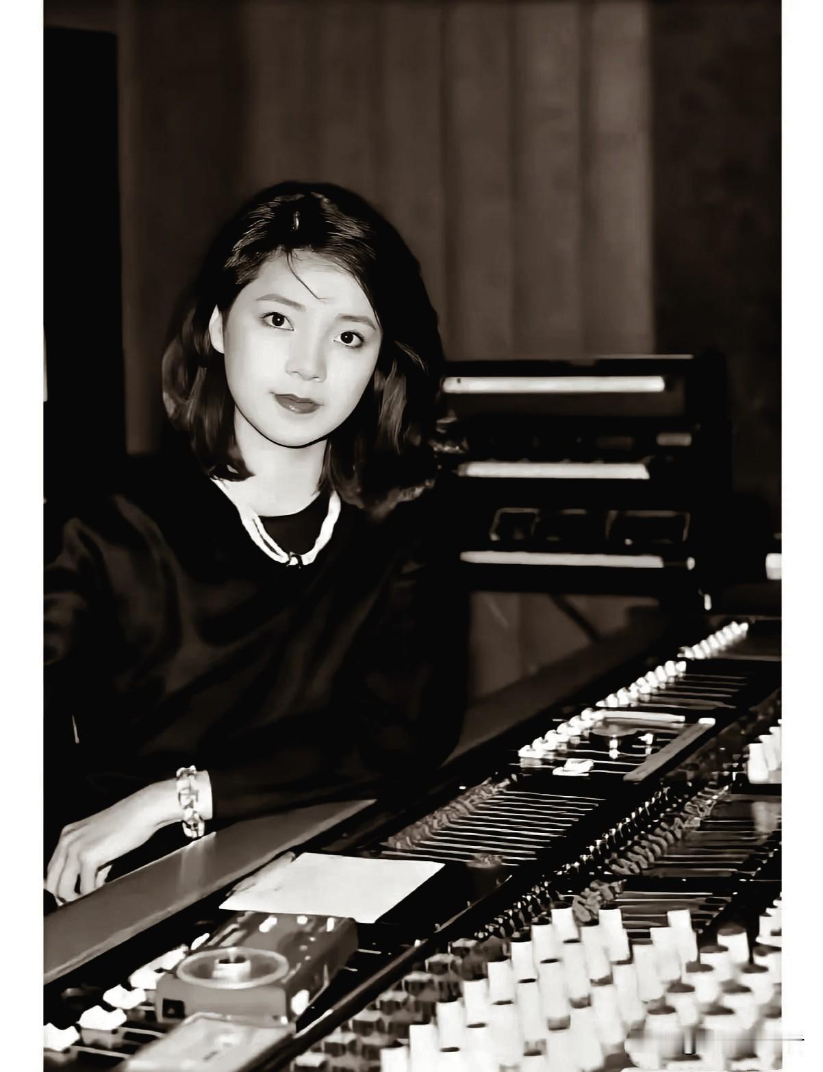 这张黑白照拍摄于1983年的一个录音棚内，邓丽君身着简约黑衣，利落的短发衬得脸庞