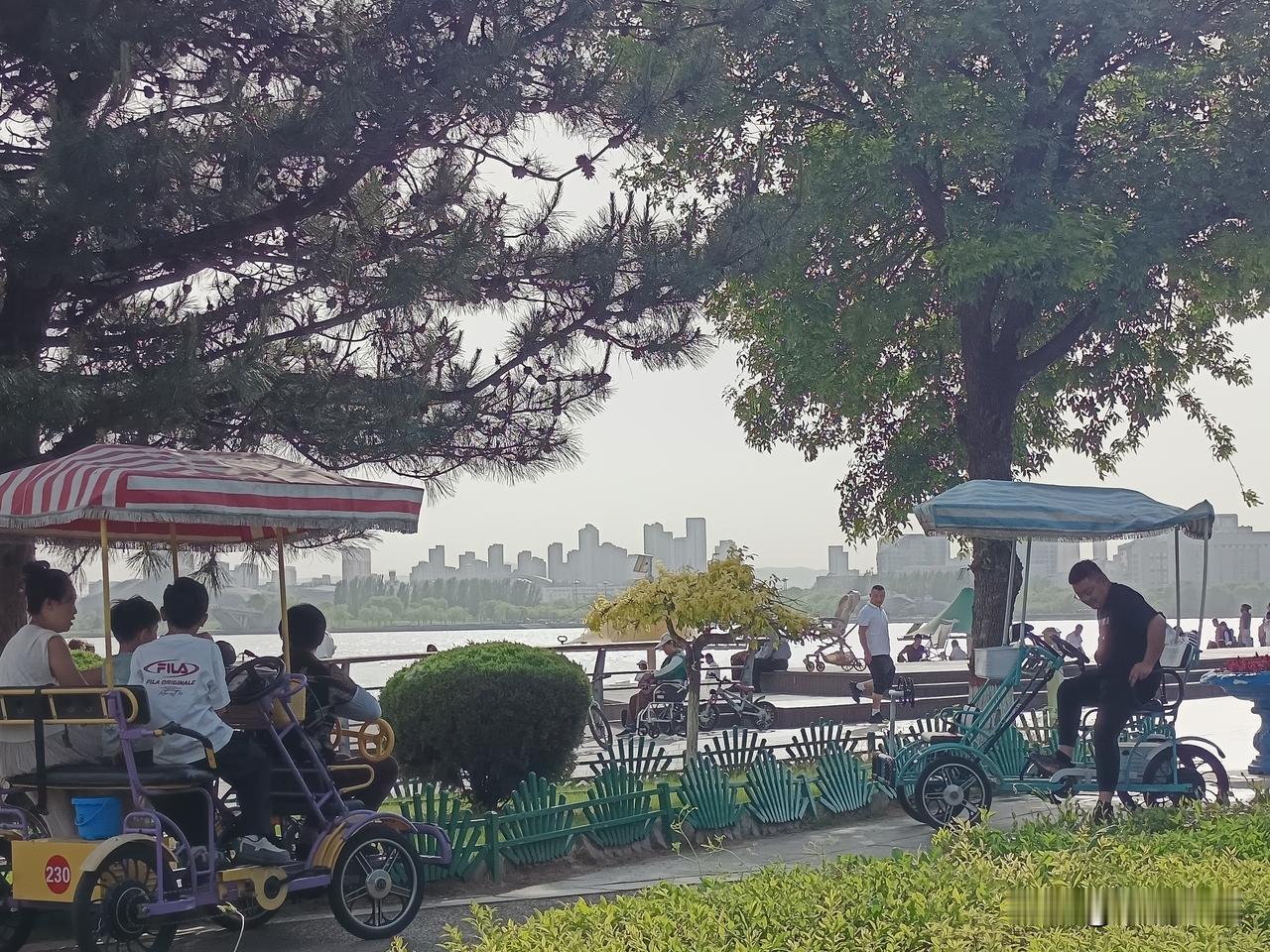 《夏日沙滩》
清凉夏日风摇柳，碧水连天接湖平。
戏水沙滩人笑语，拾贝稚子步轻盈。