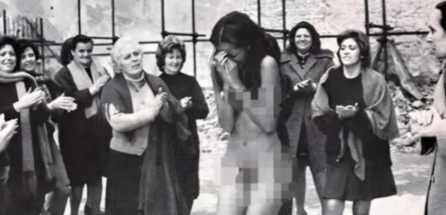 1945年的法国，一个女人被赤裸着拽在街头中间，一群女人在围观她，她只能掩面而泣