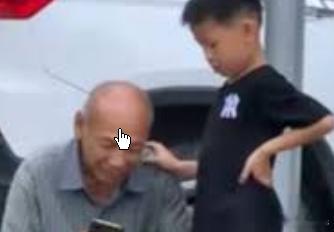 社牛小朋友蹭邻居爷爷手机看视频在湖南省邵阳市，一个小男孩看到邻居家的老人在休息时