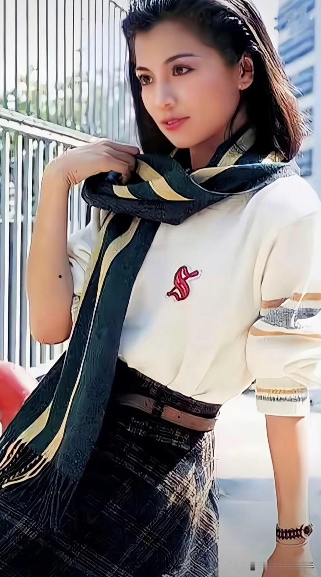 翁美玲穿搭～简约白上衣缀复古徽章，丝巾随意缠绕添慵懒，格纹半裙收束腰线，把80年