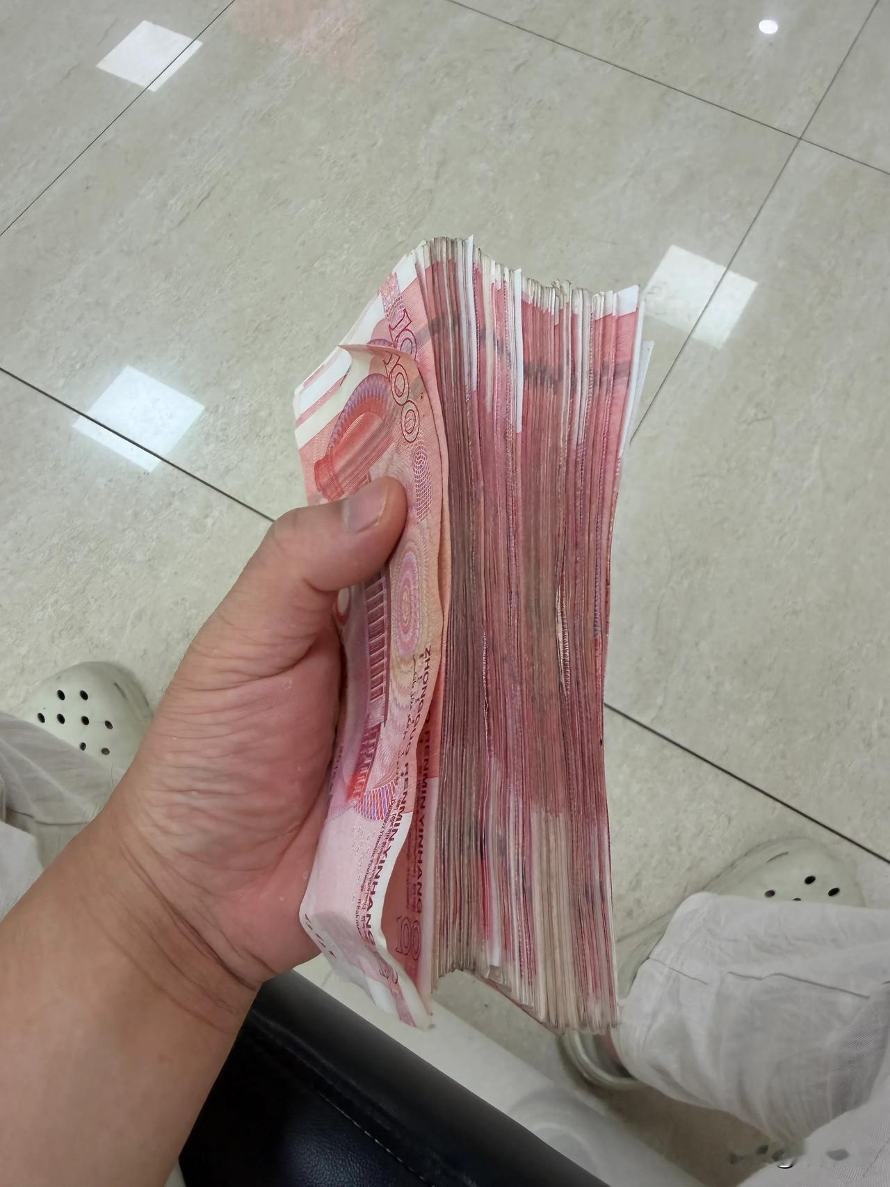 经常用手机支付，对现金实物都没感觉了，没想到2万块钱现金这么厚，一只手刚好握住[